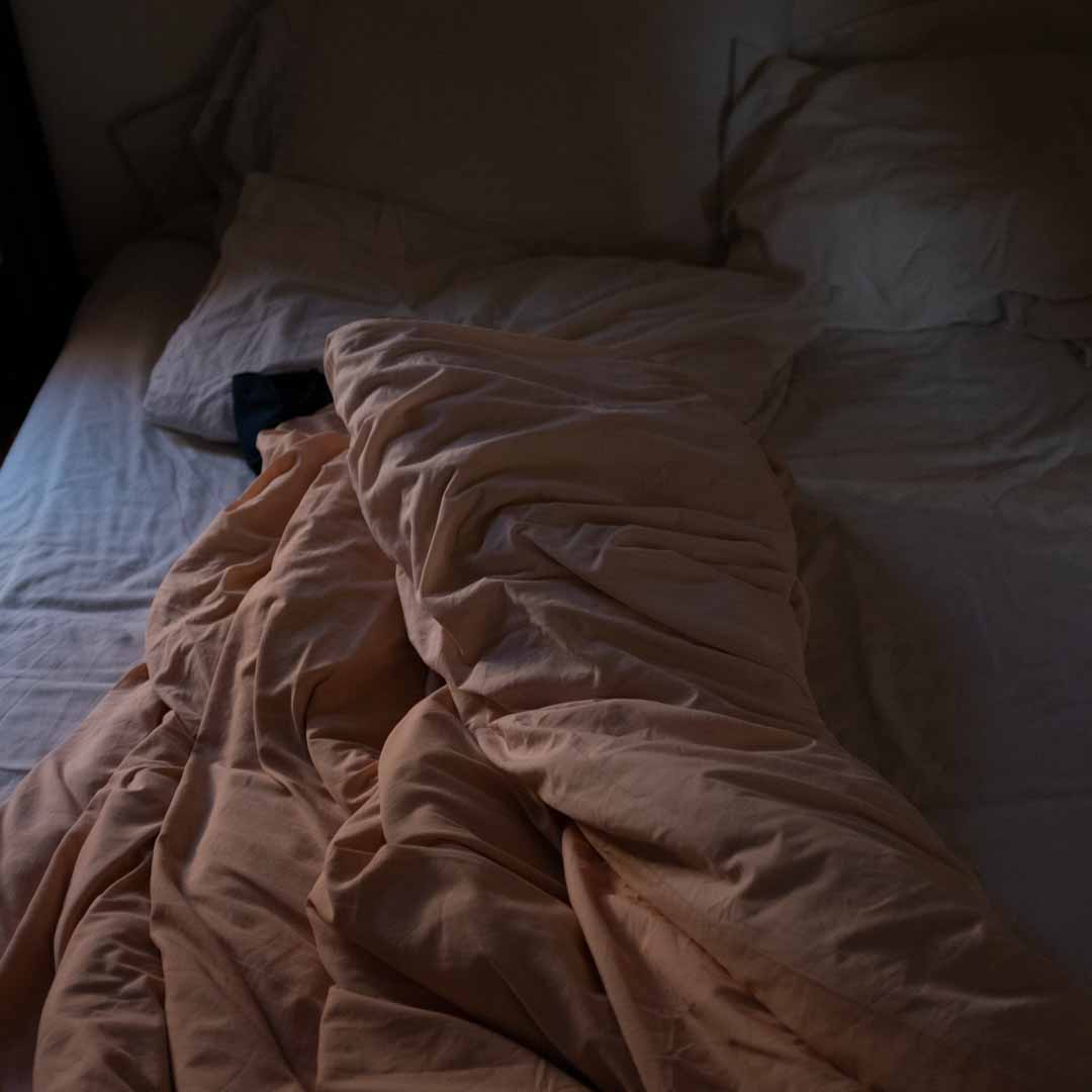 Cama deshecha con luz tenue