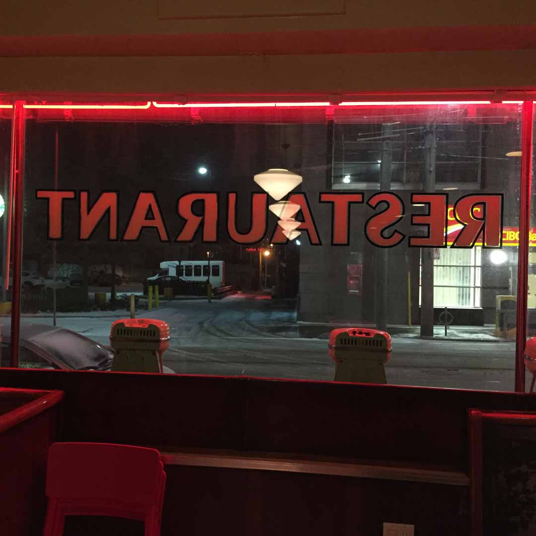 Cartel de restaurante con neón rojo de noche